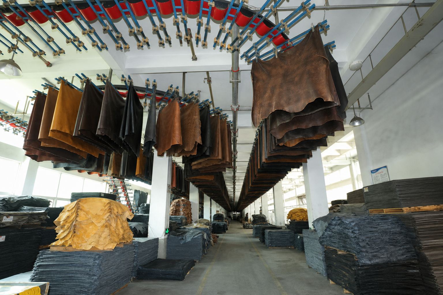 LEBO leather surface finishing area with hanging cowhide materials before belt production