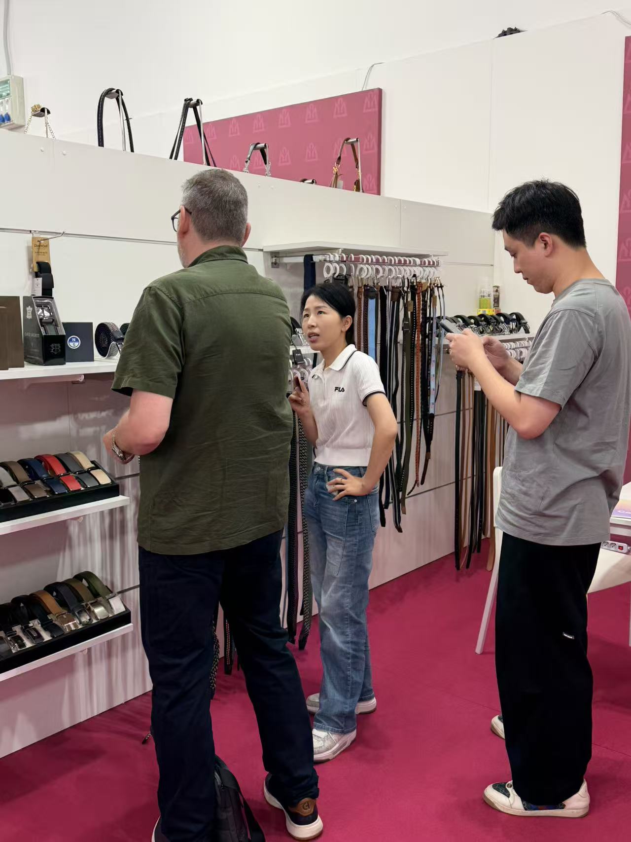 LEBO team discussing belt samples with an international buyer at the Italy trade show