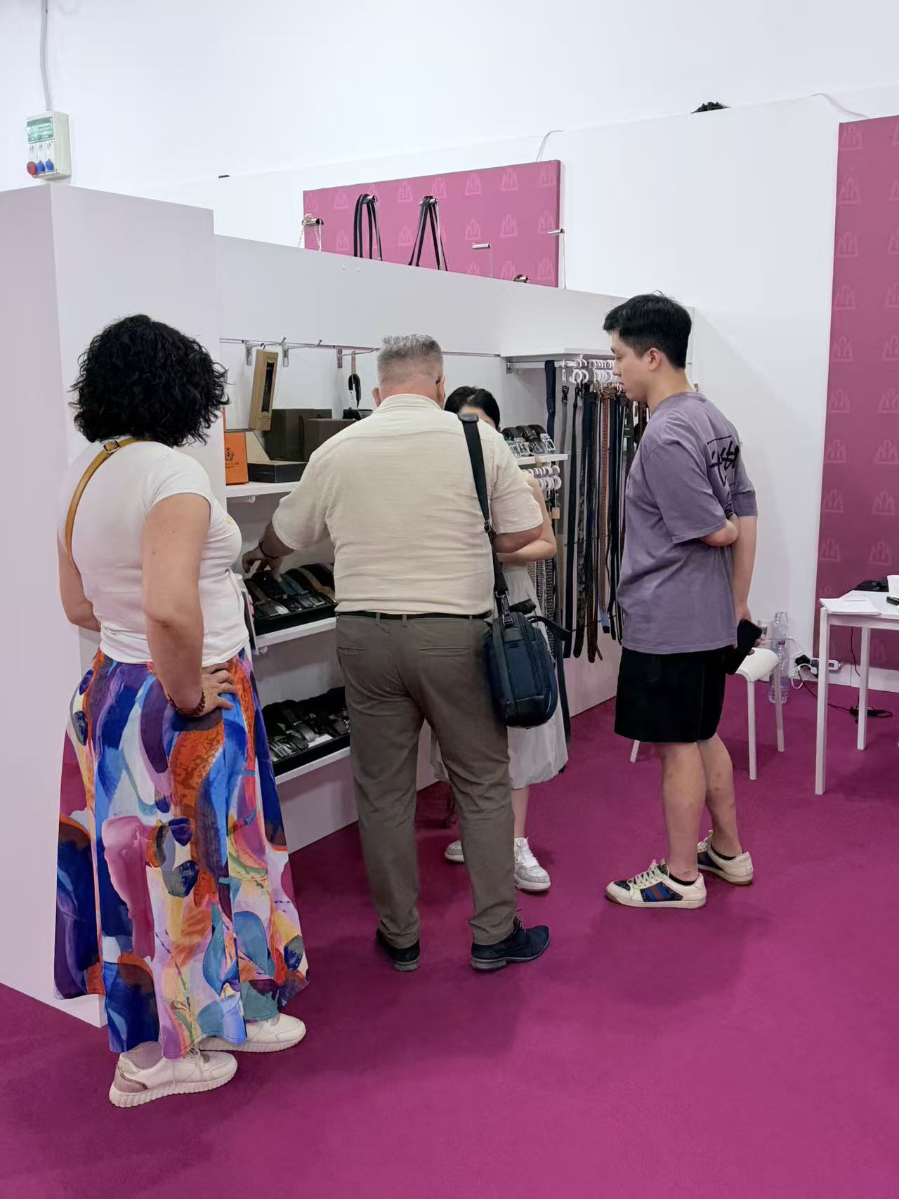 Visitors reviewing belt styles with the LEBO team at the trade show booth